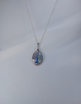 Collier pour femme avec un pendentif en médaillon arbre de vie en acier inoxydable de couleurs, bleu et argenté.