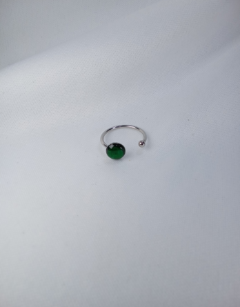 Bague pour femme ajustable en acier inoxydable. Sur le côté du bijou un petit cabochon en résine vert translucide. Créé dans notre atelier mosellan.