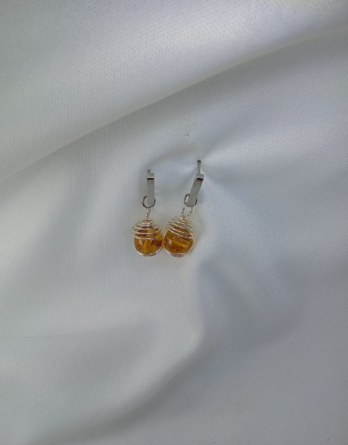 Boucles d'oreilles pour femme en pierres naturelles d'ambre capturé dans une sphère. Bijou créé en Moselle dans l'est de la France.