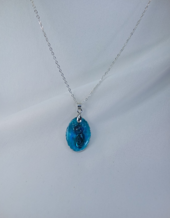 Collier en argent pour femme avec un pendentif en résine qui capture une pierre naturelle de jade turquoise. Bijou créé en Moselle dans l'est de la France.