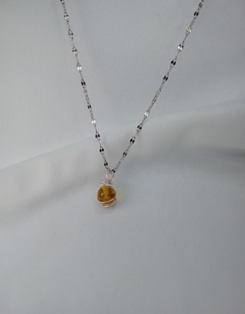 Le collier Motyla pour femme en pierres naturelles d'ambre capturé dans une sphère. Bijou créé en Moselle dans l'est de la France.